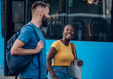 two friends in front of a blue bus